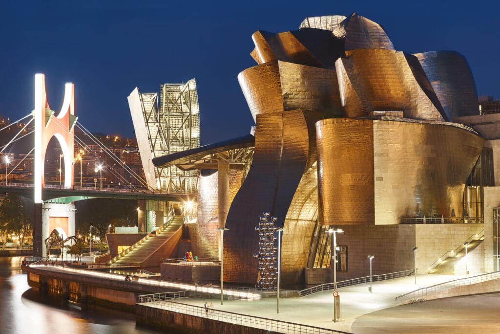 Guggenheim Museum Bilbao with titanium facade reflecting in the river