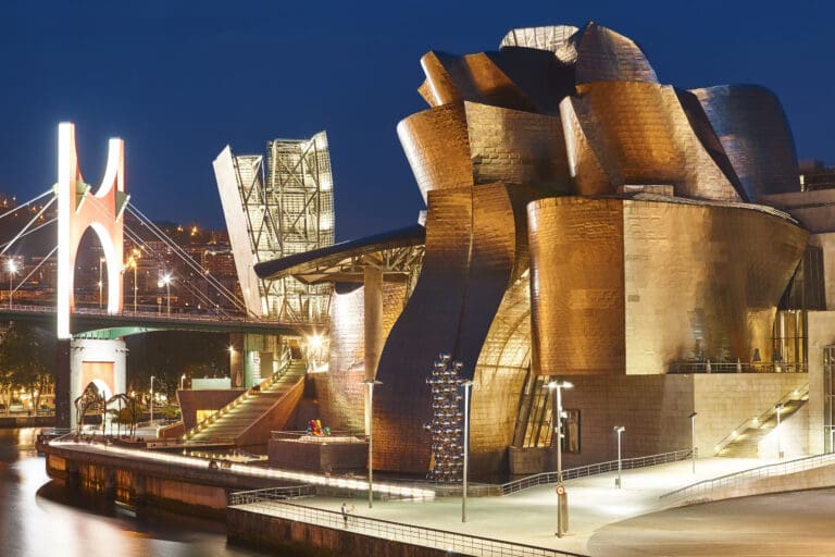 Guggenheim Museum Bilbao with titanium facade reflecting in the river